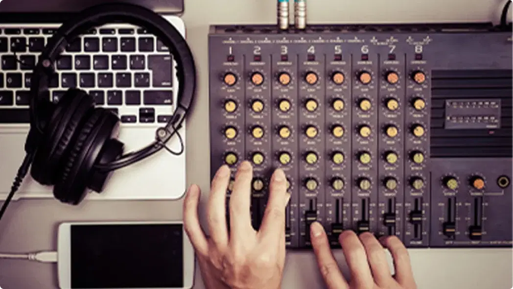 PCとヘッドホンとサウンドの機材を触っている様子