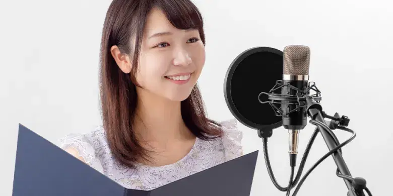 マイクに向かって女性がレコーディングしているイメージ