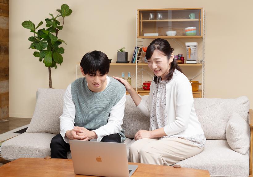 生徒と保護者がノートパソコンを見ながら面談をしている様子